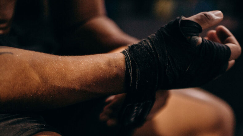 MMA fighter putting hands wraps on.