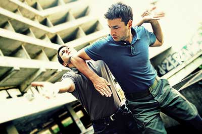 A man uses Krav Maga landing an elbow to he chin.