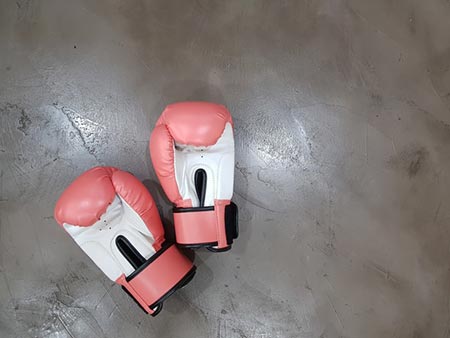 Some red boxing gloves laying on the floor during training.