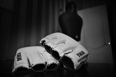 A pair of white MMA gloves sitting on a table in a room.