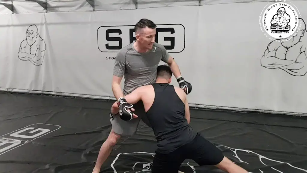 Coach Owen Roddy and fighter working takedown defence in the gym