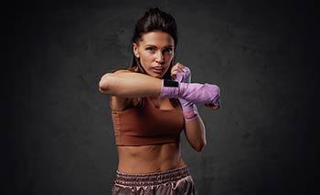 A female professional boxer throws a right-hand punch.