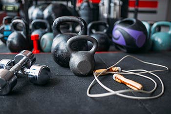 A selection of kettlebells and dumbells in a gym.