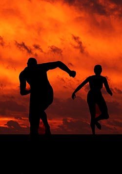 A silouette of two athletes as they train in the evening sunset.