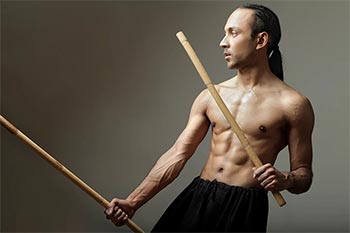 A man uses baston sticks to show the Arnis martial art.