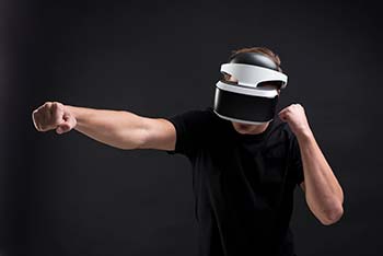 A man in black T-shirt using VR headset.