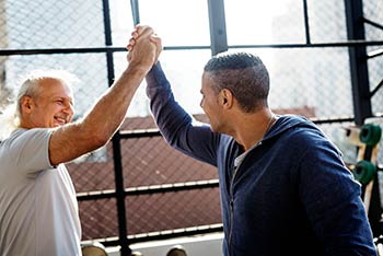 Two men high-fived one another in the gym.